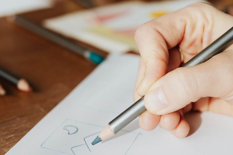 Designer dessinant des esquisses de logo au crayon dans son atelier près d'Annecy en Haute-Savoie