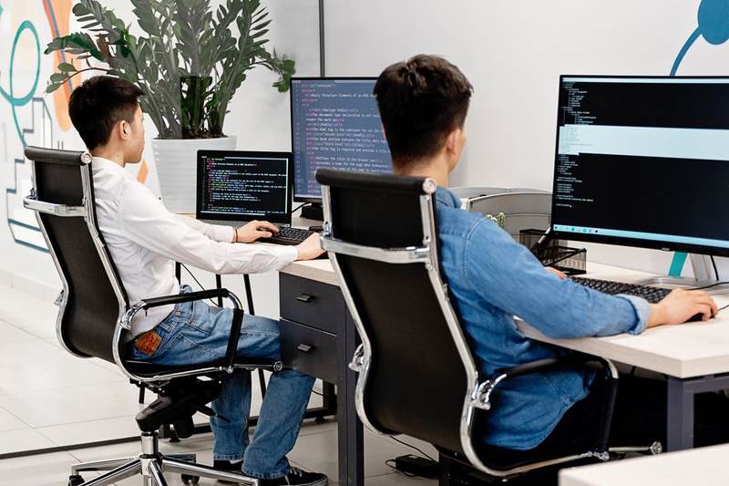 Équipe développant un logiciel métier sur mesure autour d'écrans de code, Haute-Savoie